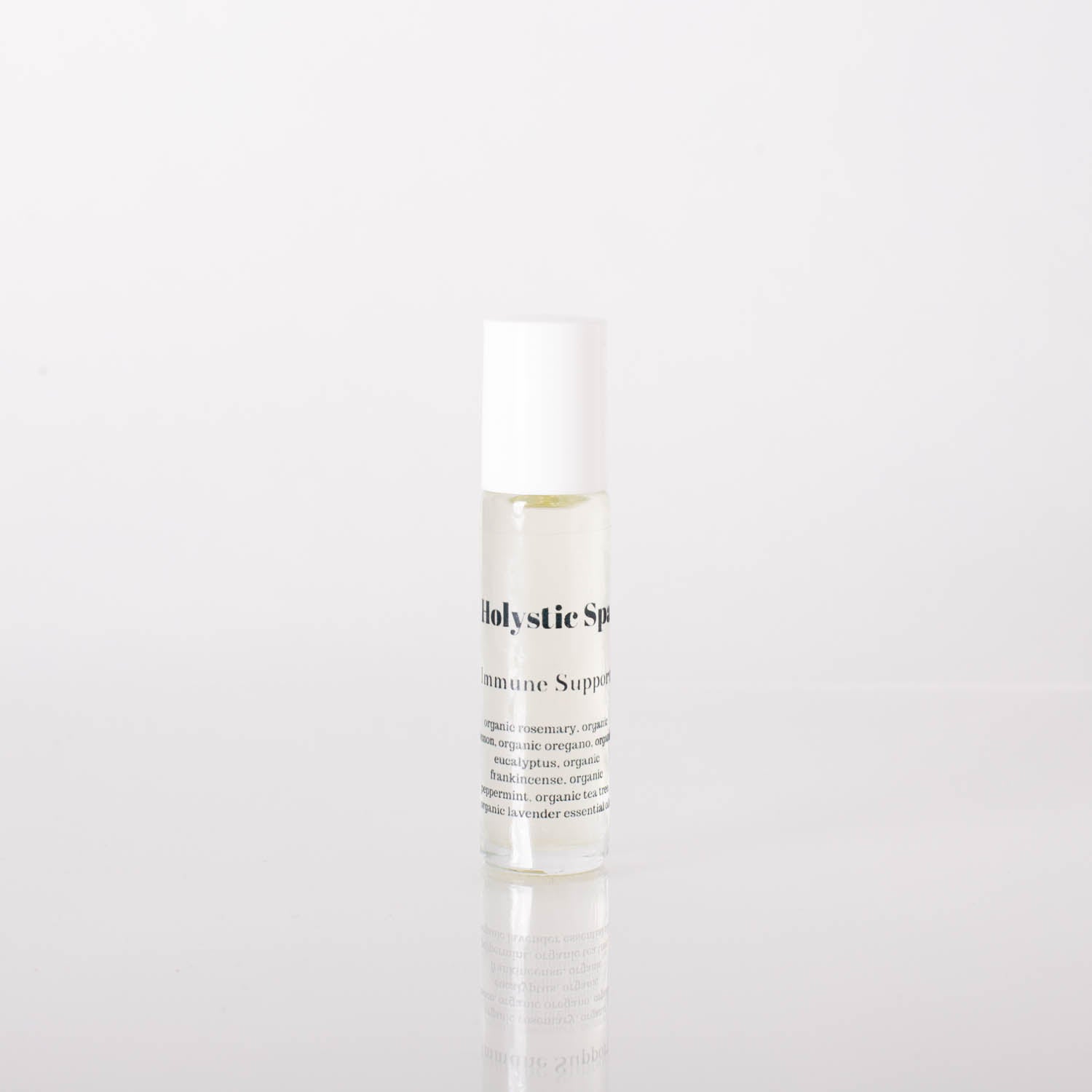 A bottle of organic Immune Support essential oil blend with a dropper, surrounded by fresh herbs and citrus fruits.