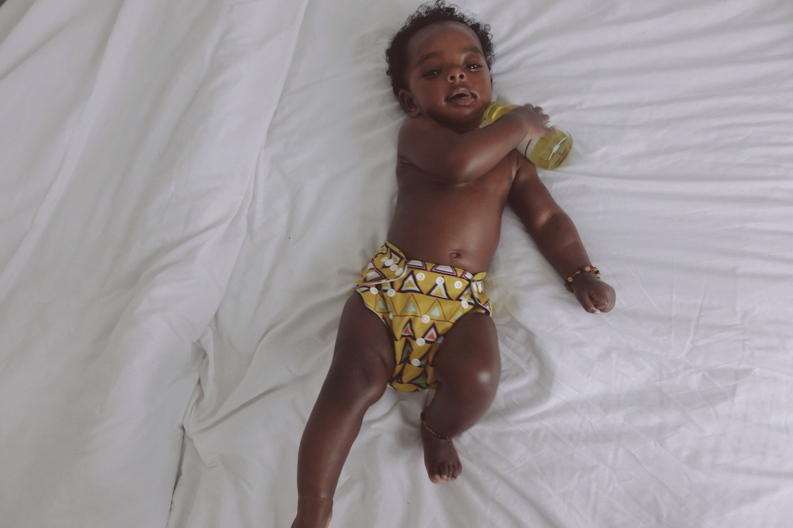 A jar of Mother and Baby Body Butter, showcasing its light yellow color and creamy texture, perfect for nourishing skin.