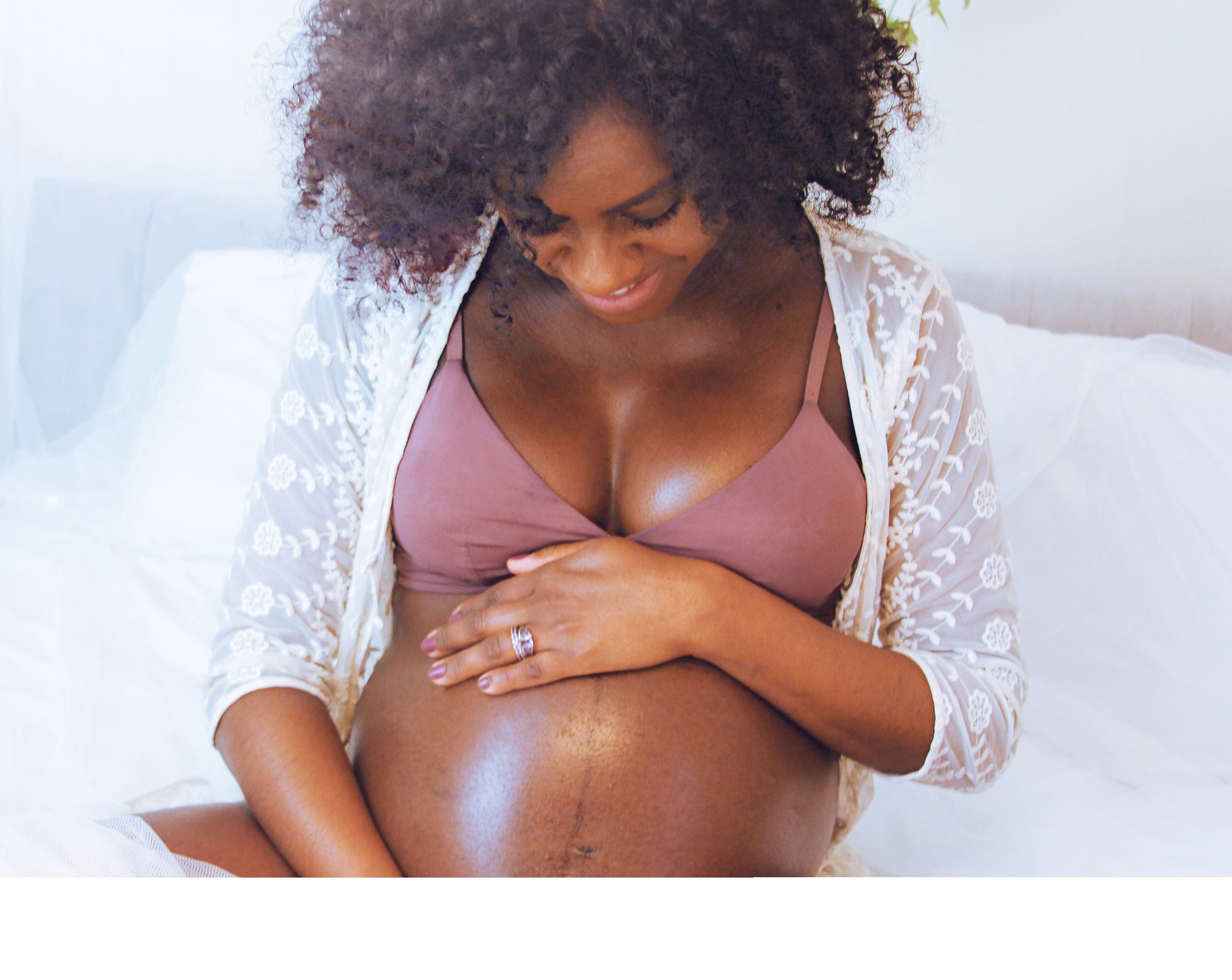 A jar of Mother and Baby Body Butter, showcasing its light yellow color and creamy texture, perfect for nourishing skin.