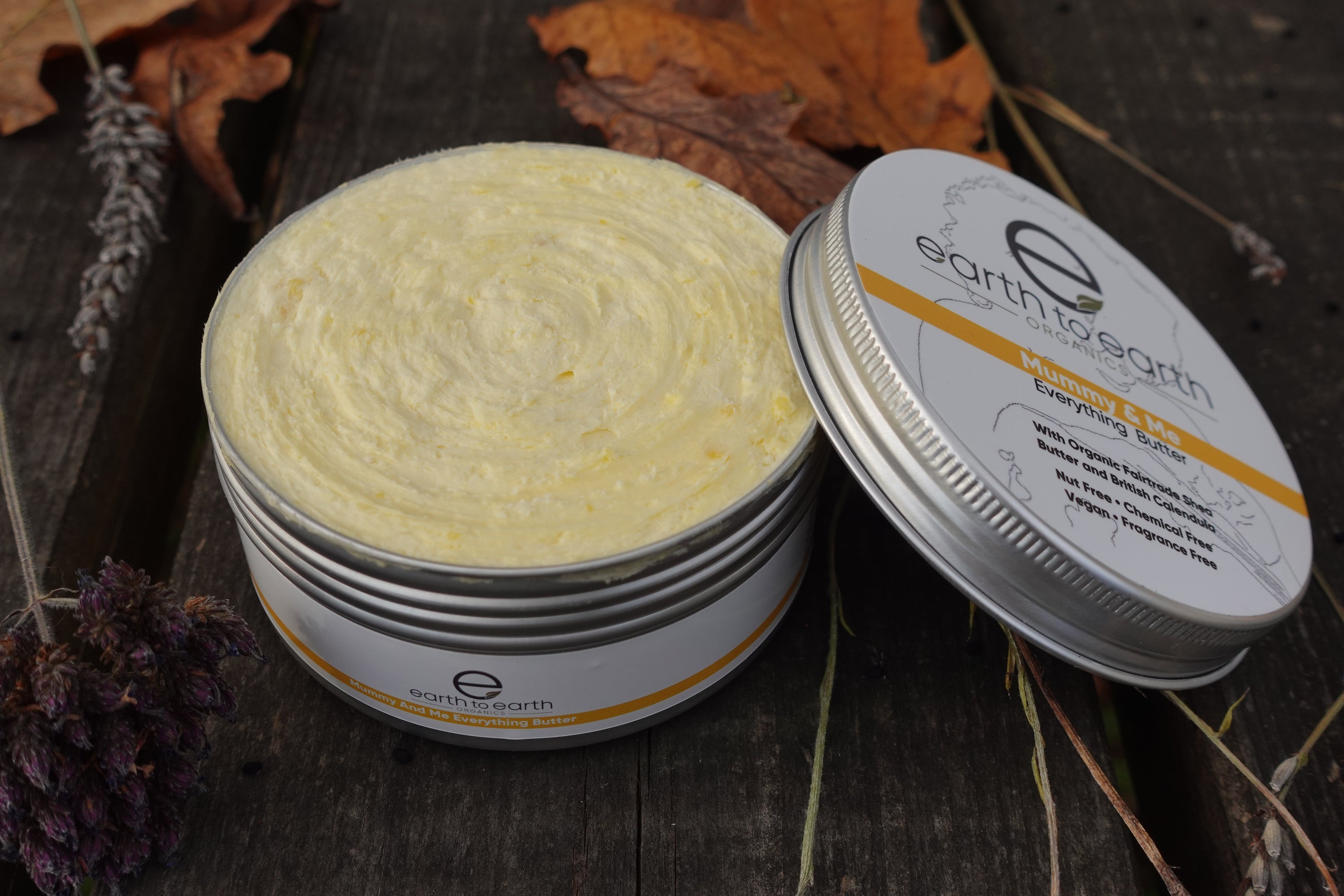A jar of Mother and Baby Body Butter, showcasing its light yellow color and creamy texture, perfect for nourishing skin.