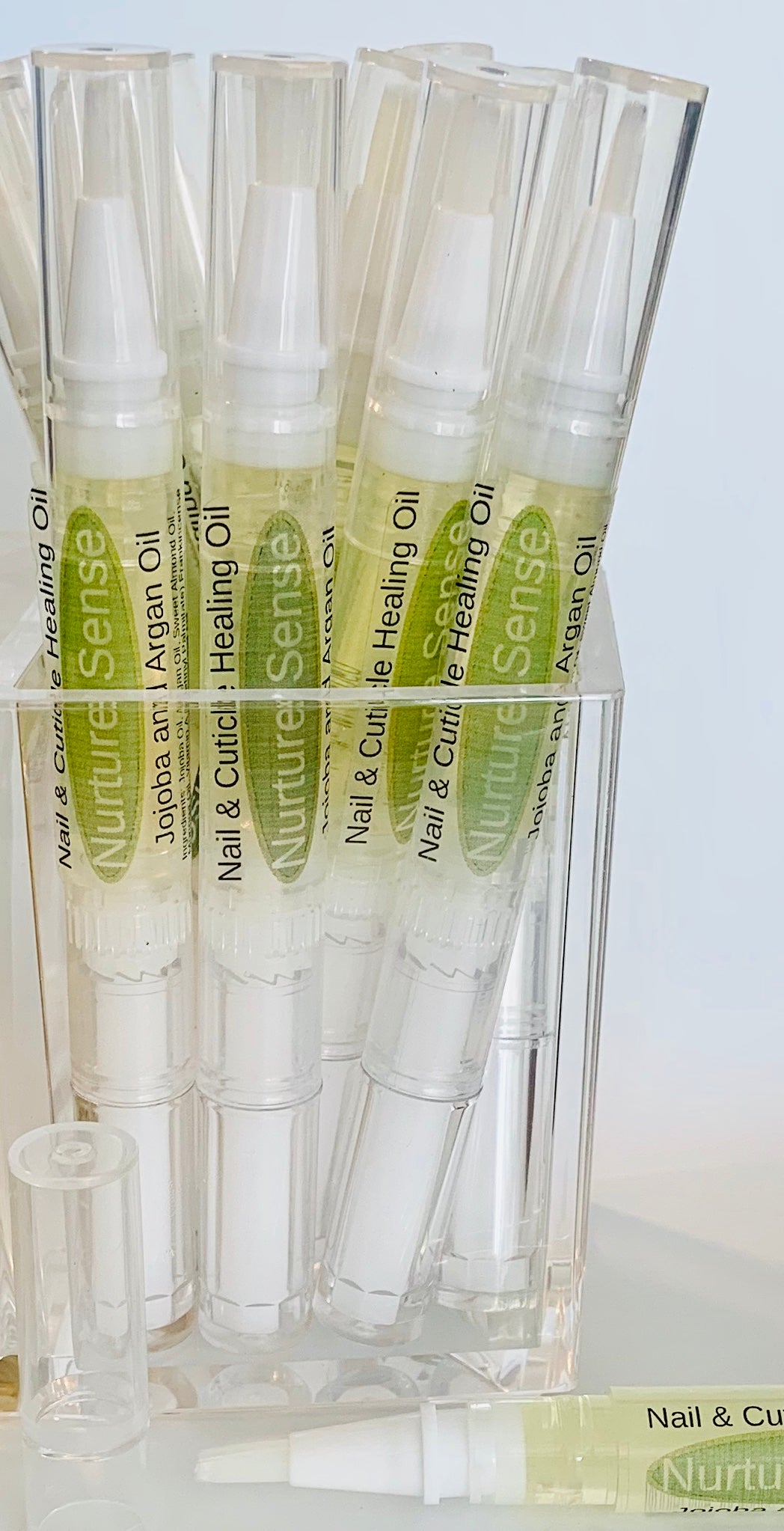 Nail & Cuticle Healing Oil in a twist-up pen with brush applicator, showcasing its organic ingredients and sleek design.