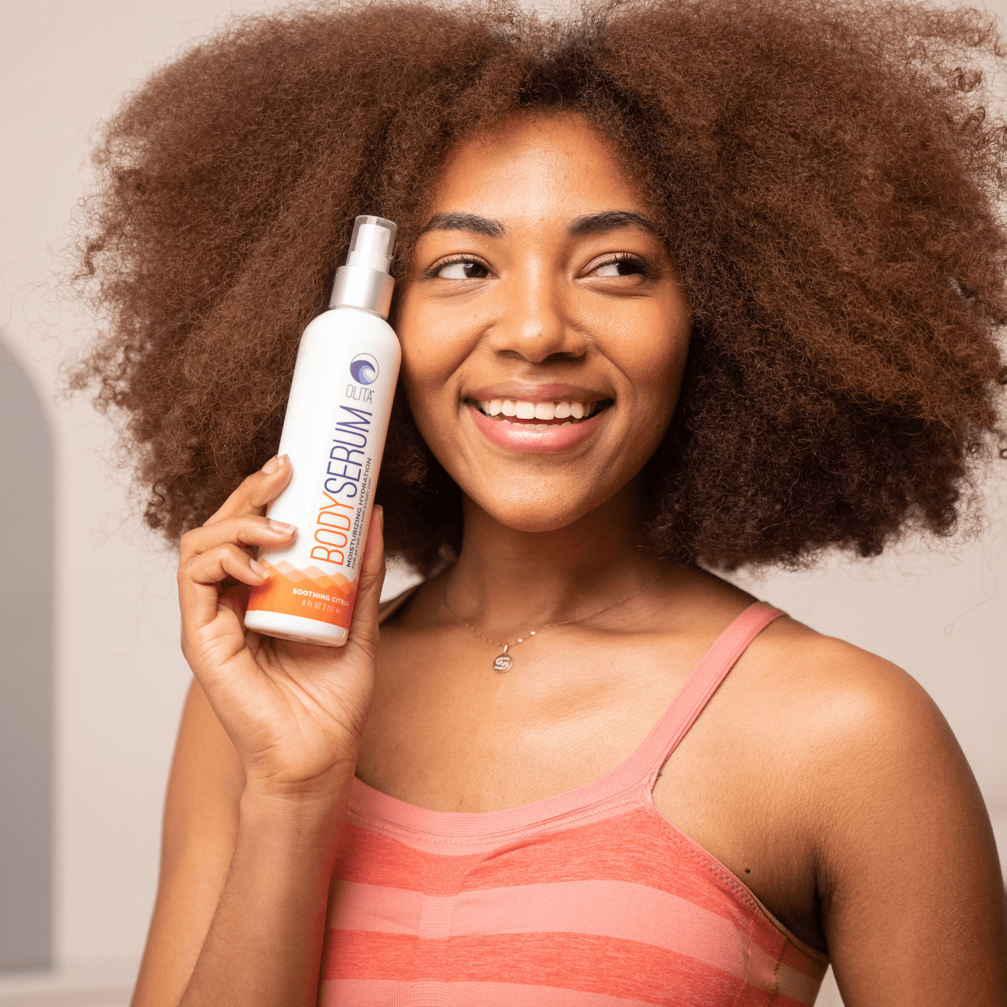 OLITA Hydrating Body Serum in a sustainable bottle with a refreshing citrus scent, showcasing its light oil texture and natural ingredients.