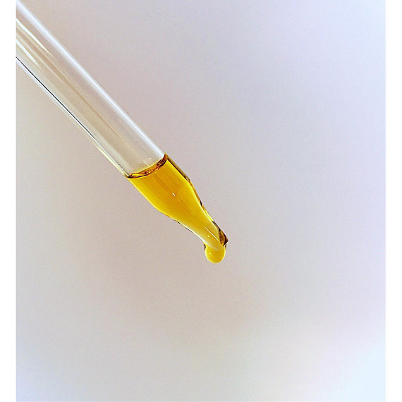 A bottle of Organic Facial Serum featuring a blend of natural oils for anti-aging and wrinkle reduction, set against a soft, neutral background.