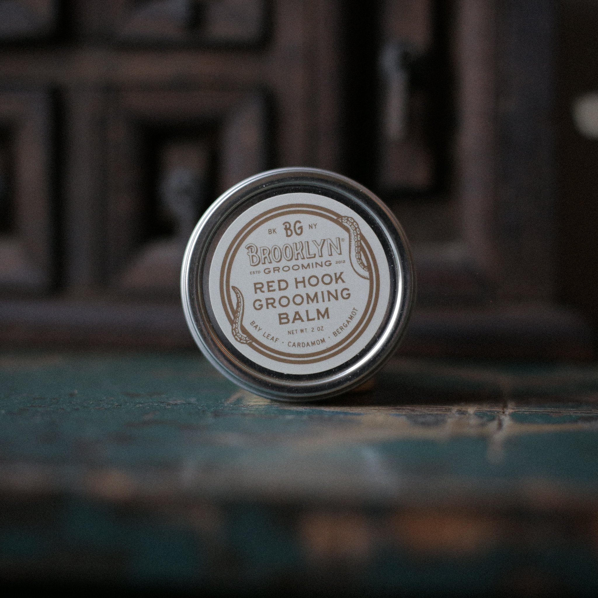 Red Hook Grooming Balm in a seamless aluminum tin, showcasing its natural ingredients and spiced bay scent.