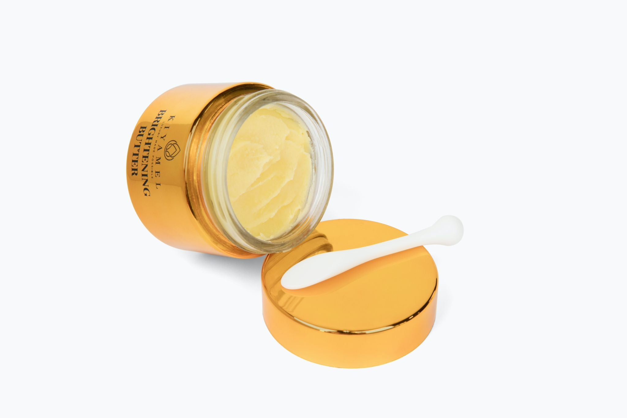A jar of Revolutionary Brightening Butter with a creamy texture, surrounded by natural ingredients like rosehip oil and shea butter.