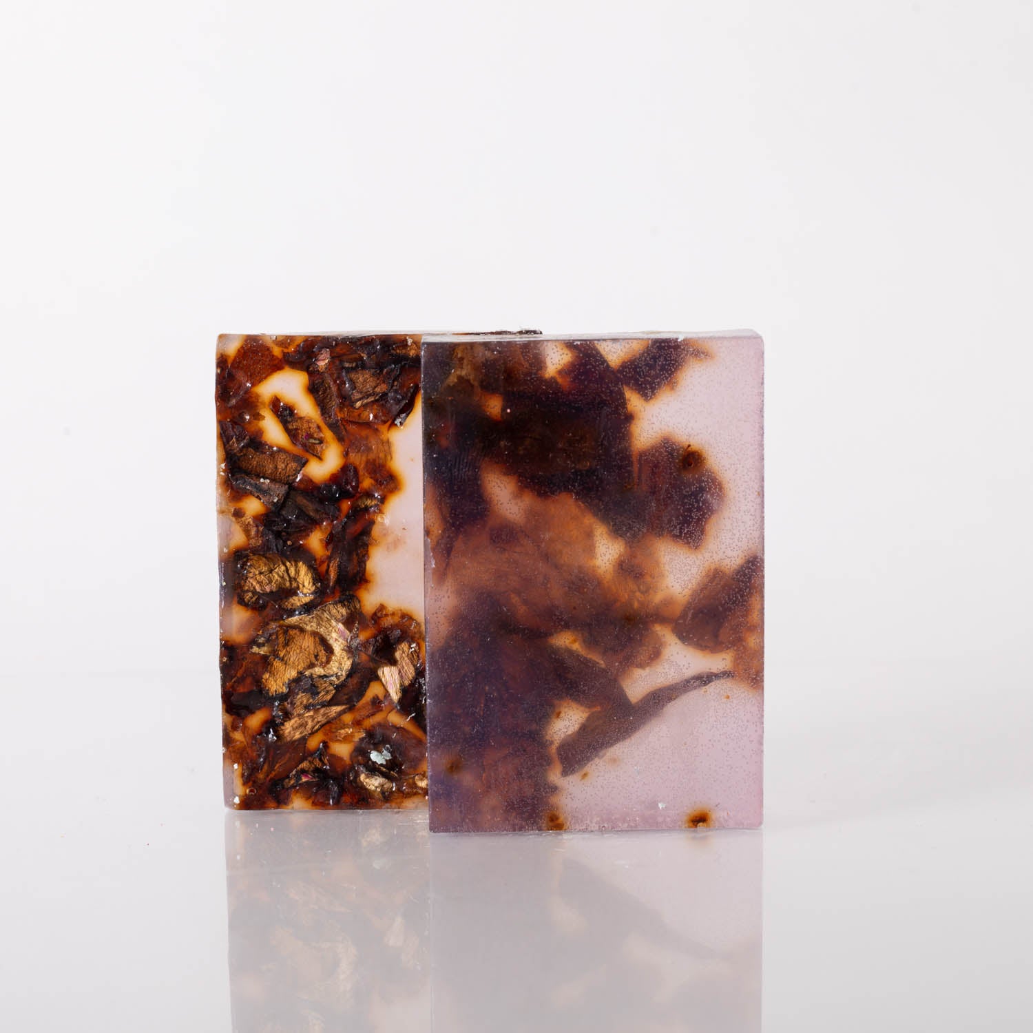 A bar of Rose Petal Face & Body Soap with dried rose flowers, showcasing its natural ingredients and moisturizing properties.