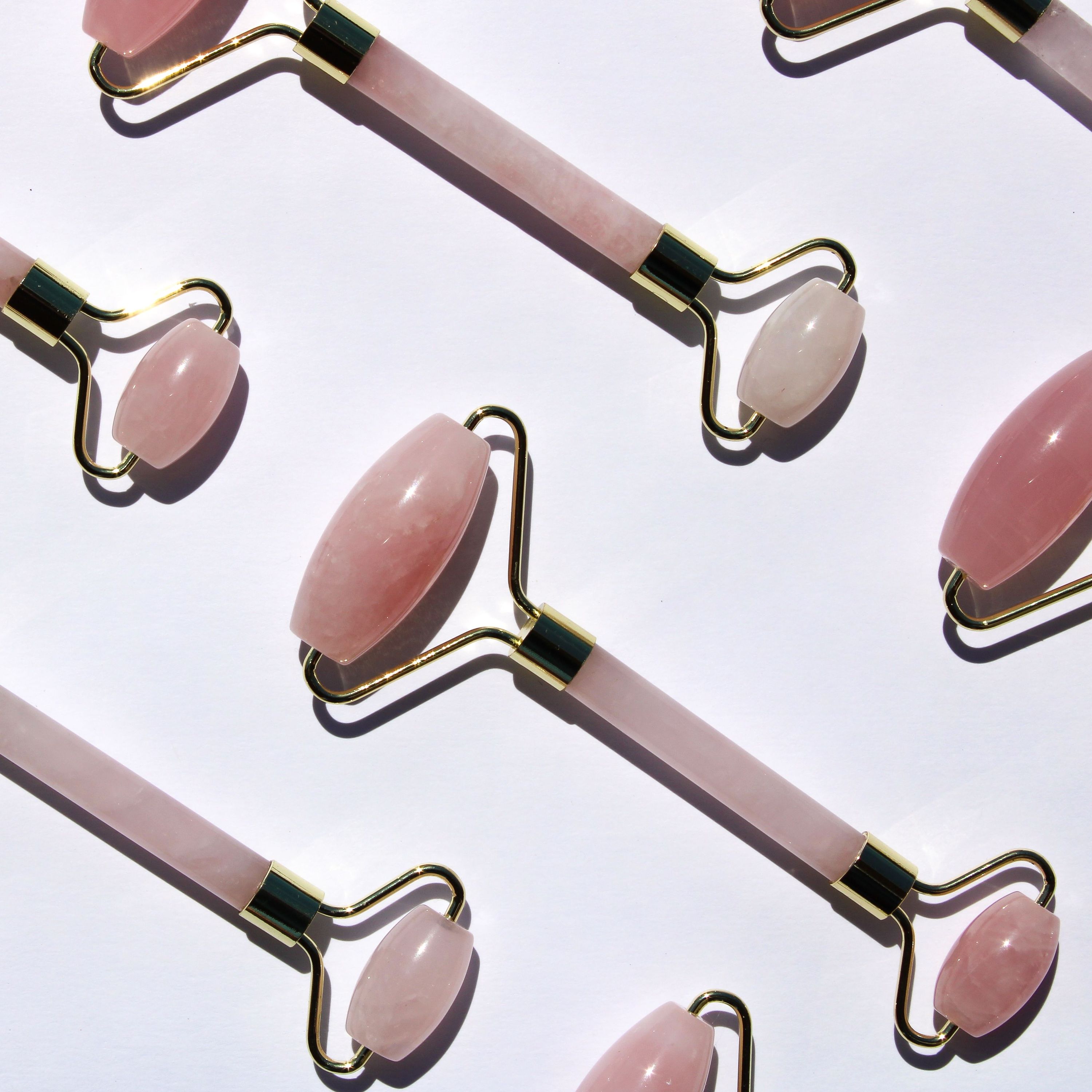 A beautiful Rose Quartz Facial Roller with a smooth, pink stone and a silver handle, ideal for skincare routines.