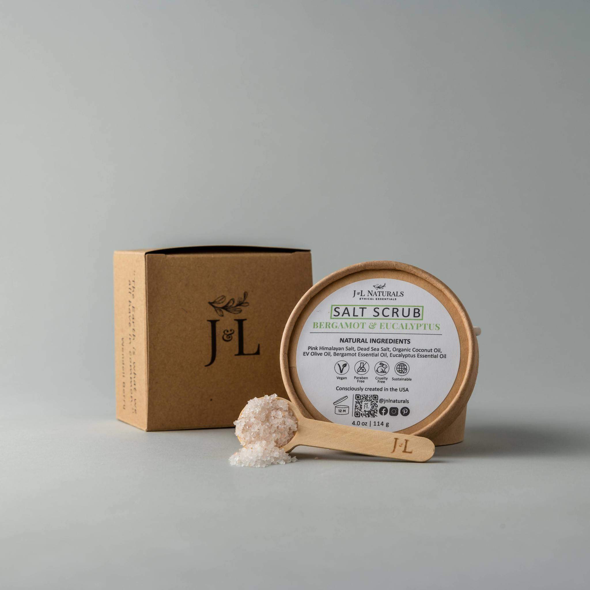 A jar of Salt Scrub featuring pink Himalayan salt and dead sea salt, with a scoop beside it, showcasing its natural exfoliating ingredients.