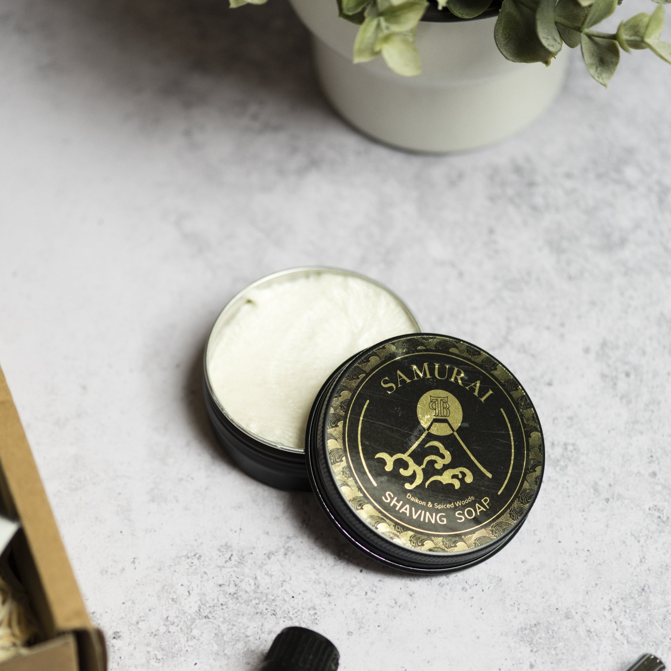 A tin of Samurai Shaving Soap featuring a rich, creamy texture and vibrant packaging, ideal for a luxurious shaving experience.