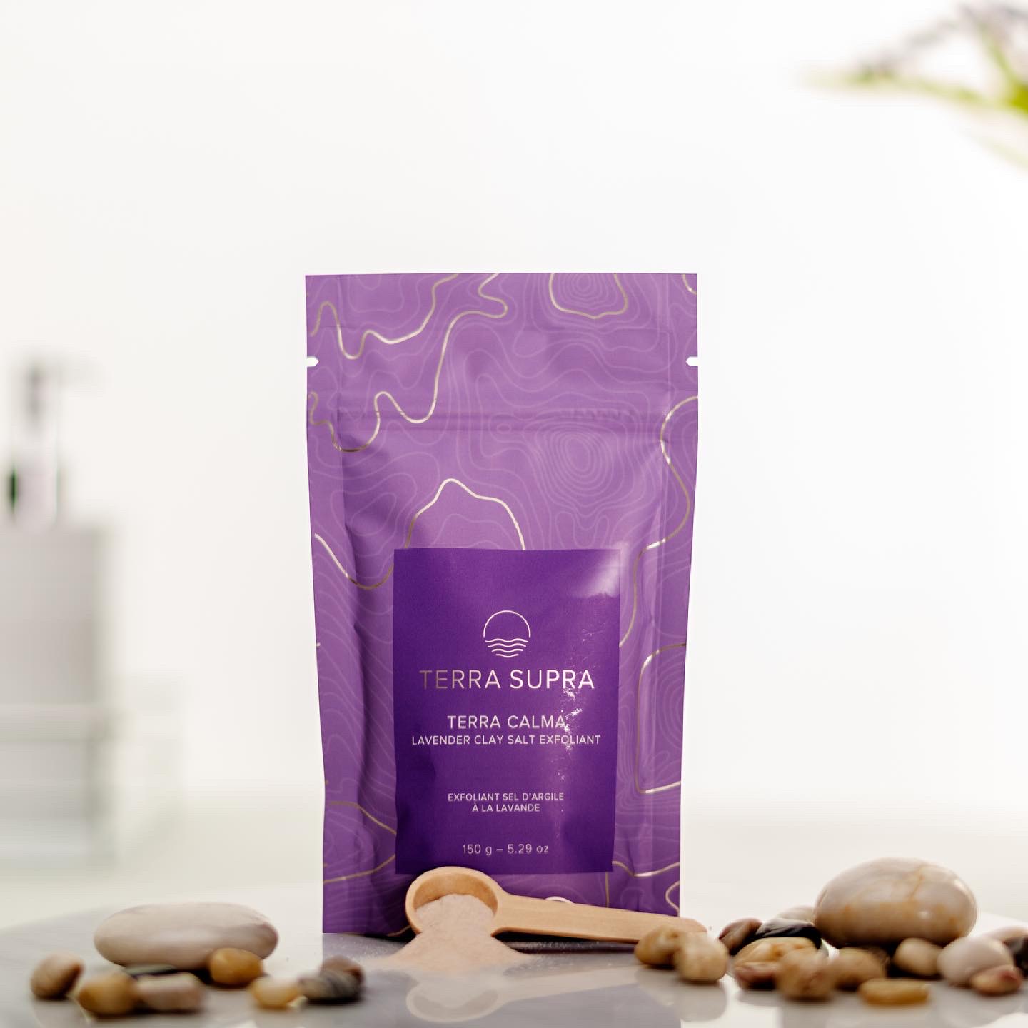 Terra Calma Lavender Clay Salt Exfoliant in a 150g container, showcasing its fine grain texture and soothing lavender color.