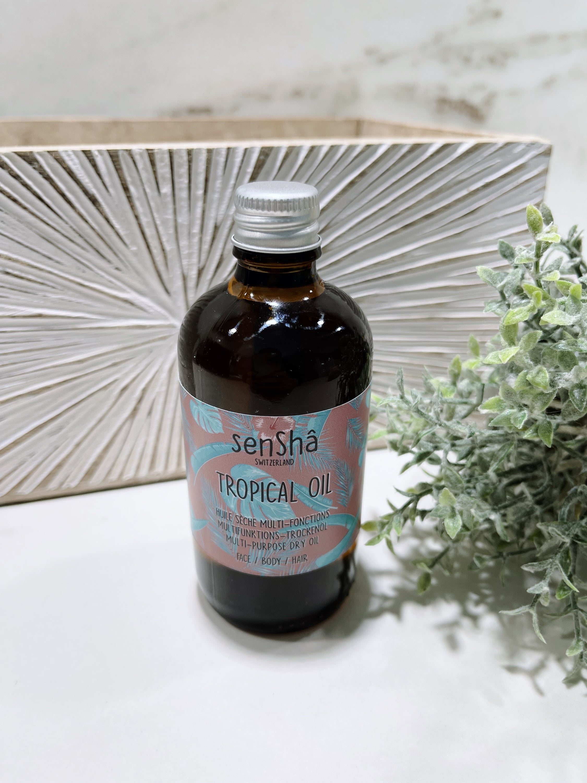 100 ml bottle of Tropical Oil with Tahitian Monoï, suitable for face, body, and hair, featuring a tropical design.