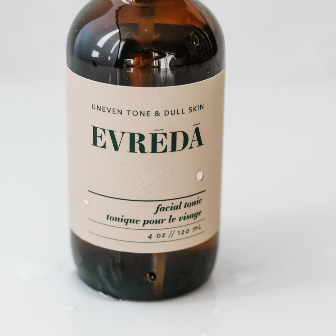 A refreshing facial tonic mist bottle with a floral design, showcasing its glow-boosting properties for uneven tone and dull skin.