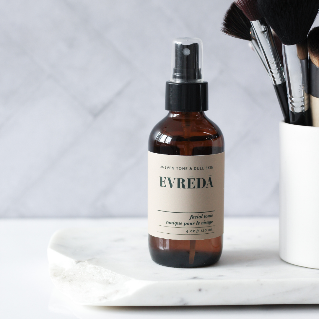 A refreshing facial tonic mist bottle with a floral design, showcasing its glow-boosting properties for uneven tone and dull skin.