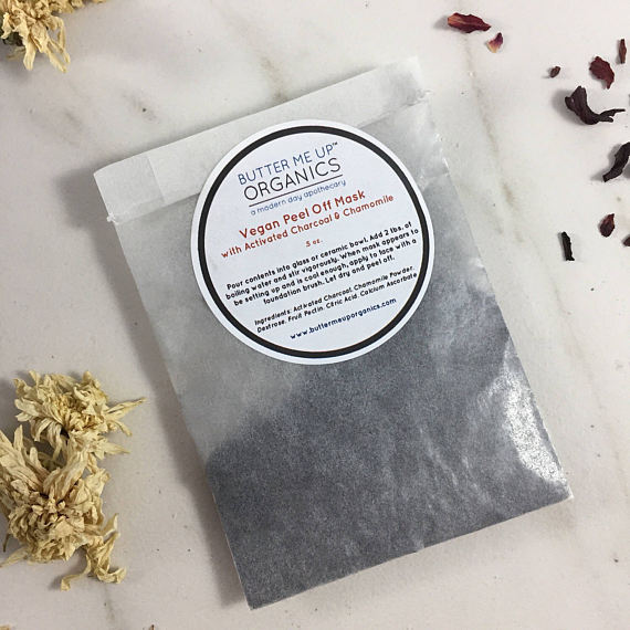 A vegan activated charcoal peel-off mask packet with natural ingredients, showcasing its eco-friendly packaging and easy application method.