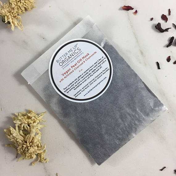 A vegan activated charcoal peel-off mask packet with natural ingredients, showcasing its eco-friendly packaging and easy application method.