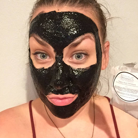 A vegan activated charcoal peel-off mask packet with natural ingredients, showcasing its eco-friendly packaging and easy application method.