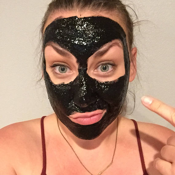 A vegan activated charcoal peel-off mask packet with natural ingredients, showcasing its eco-friendly packaging and easy application method.