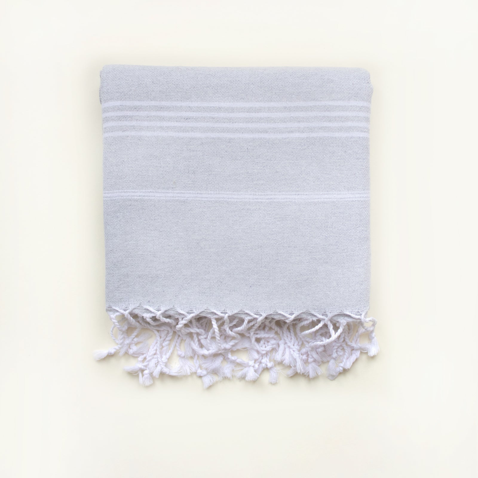 Light gray DRAMA QUEER embroidered towel, showcasing its tight-knit texture and versatility for beach, gym, and spa use.