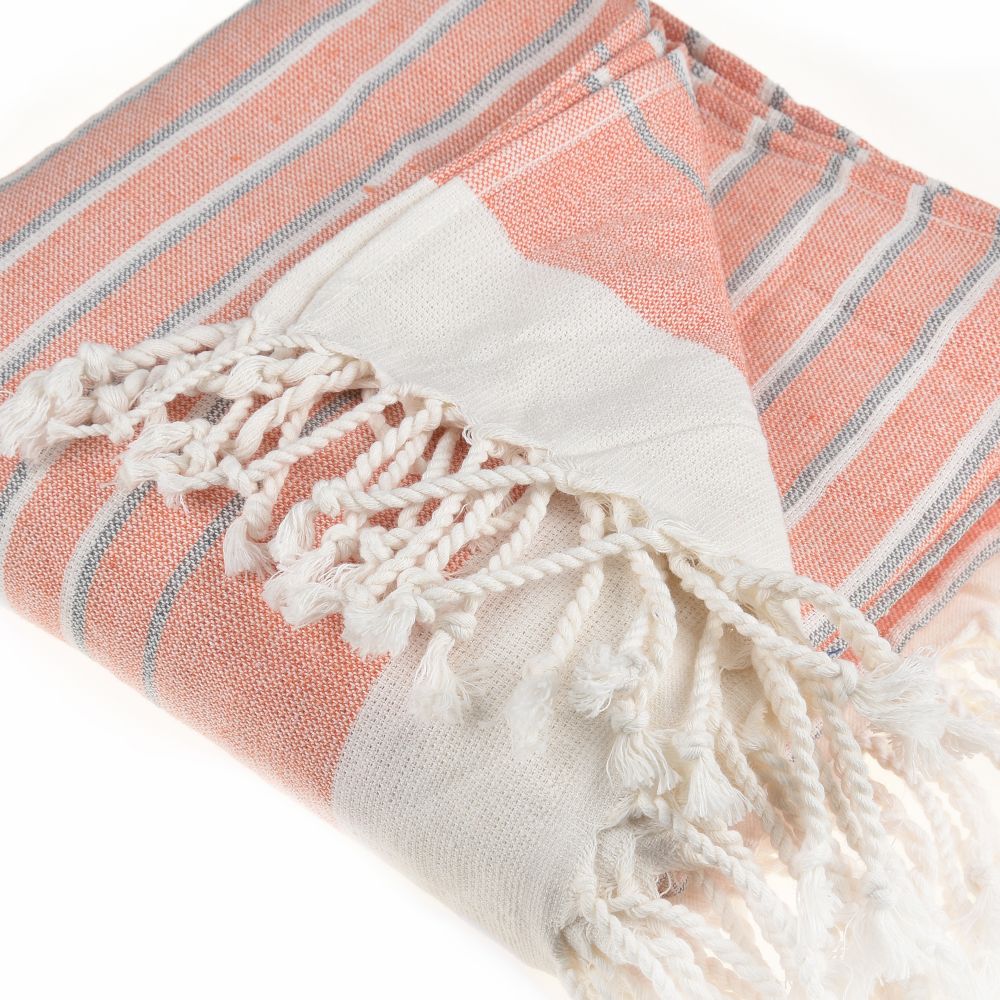 Eftelia Beach Towel displayed on a sandy beach, showcasing its vibrant colors and traditional woven design, perfect for summer outings.