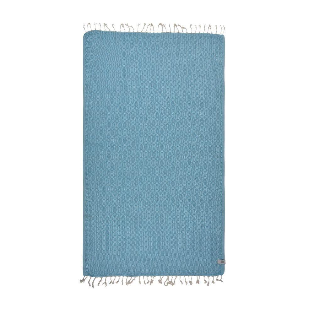 Malta Beach Towel displayed on a sandy beach, showcasing its vibrant colors and traditional woven design, perfect for beach and outdoor activities.