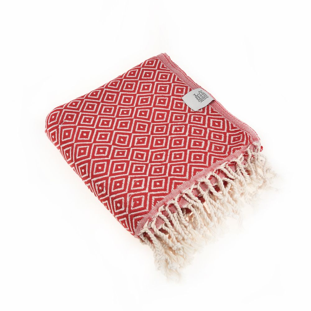 Malta Beach Towel displayed on a sandy beach, showcasing its vibrant colors and traditional woven design, perfect for beach and outdoor activities.