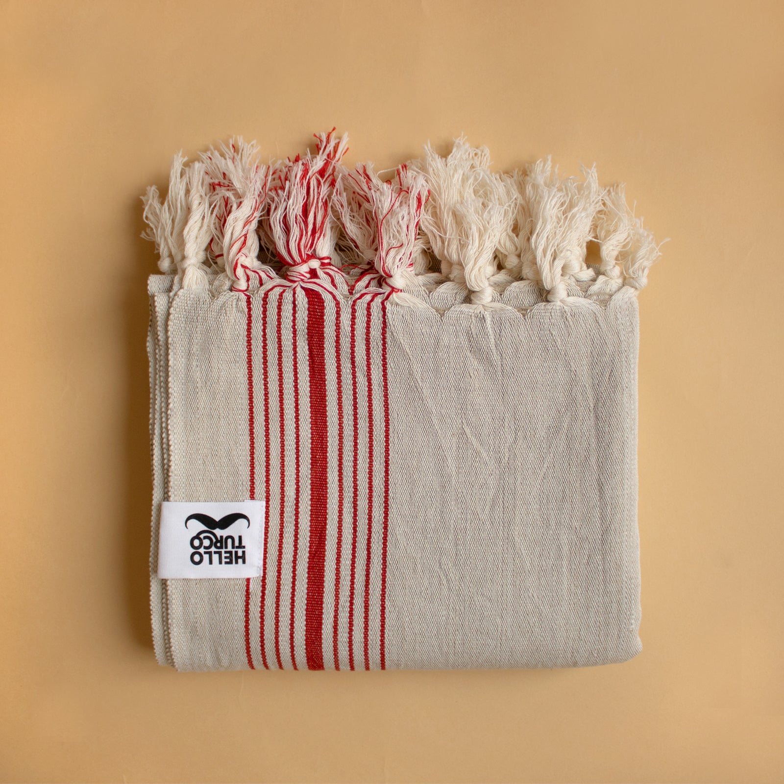 Melek Handwoven Towel featuring a raw beige base with traditional red lines, showcasing its artisanal craftsmanship and organic cotton material.