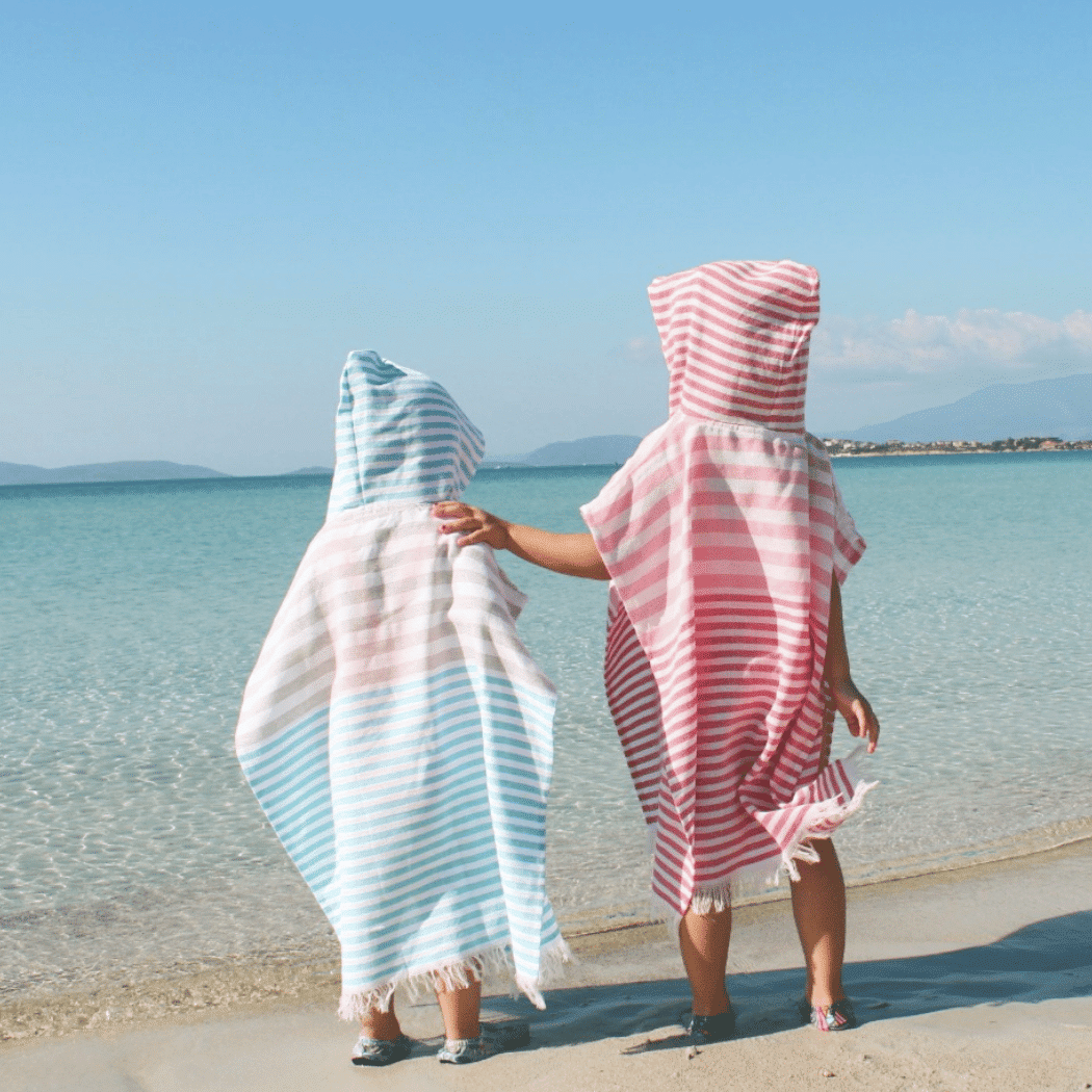 Playa Kids Poncho Towel in blue, made from 100% cotton, displayed in a recycled gift box, perfect for little adventurers.