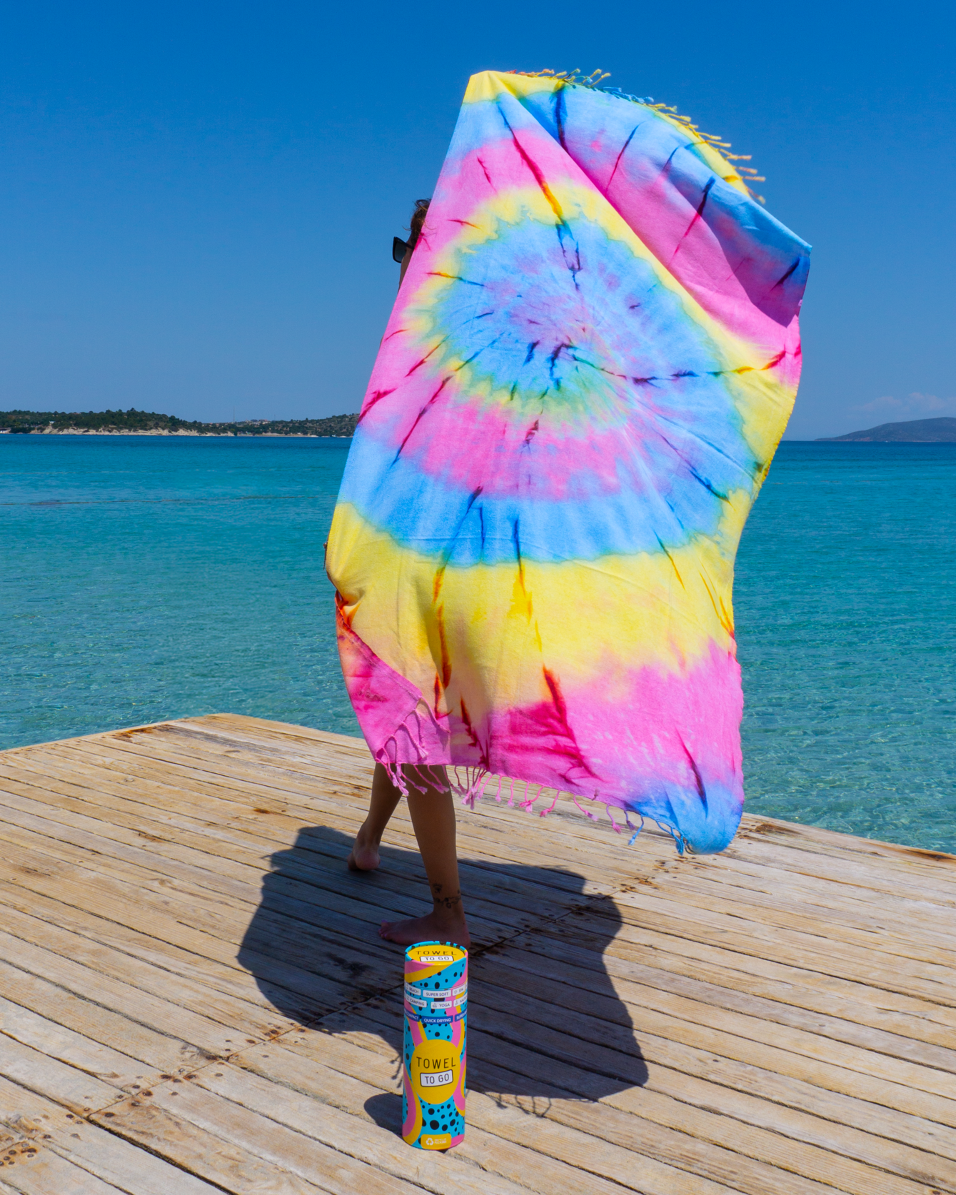 Vibrant blue and yellow tie-dye beach towel made from 100% cotton, displayed in a recycled gift box.