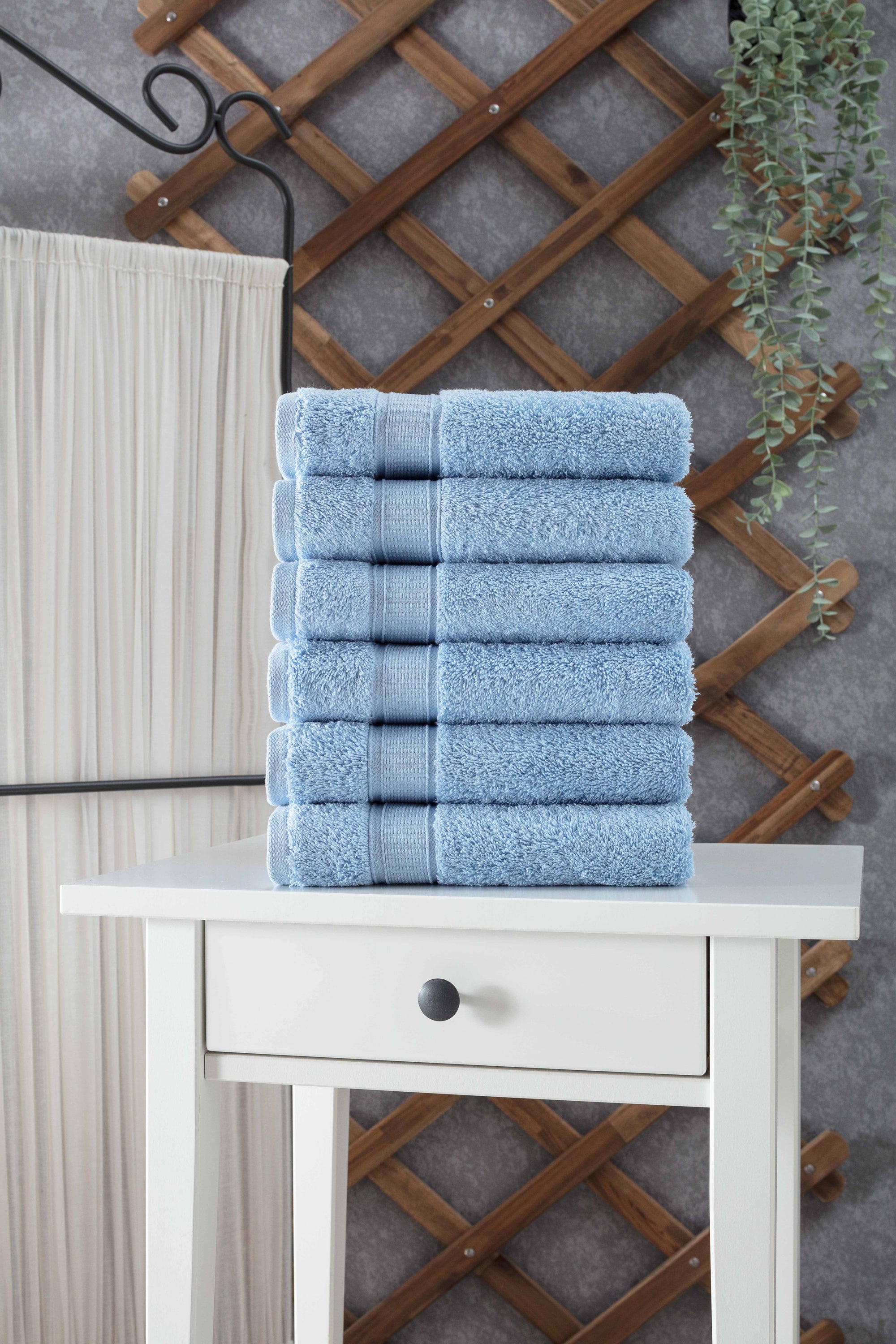 A set of six luxurious Turkish cotton hand towels in various vibrant colors, showcasing their soft texture and elegant dobby border design.