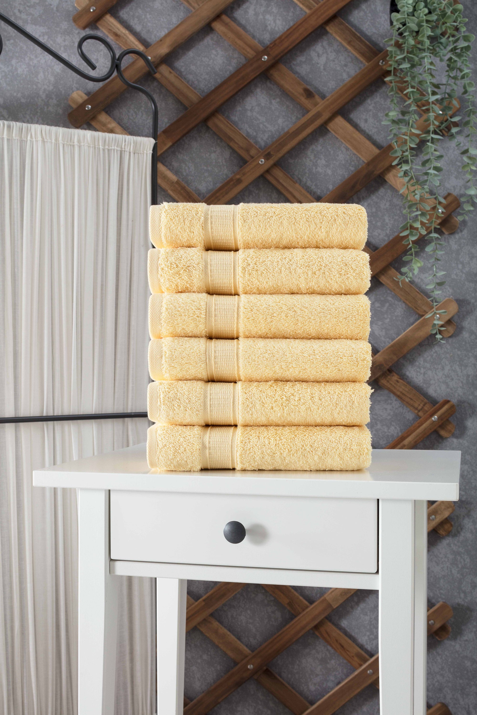 A set of six luxurious Turkish cotton hand towels in various vibrant colors, showcasing their soft texture and elegant dobby border design.