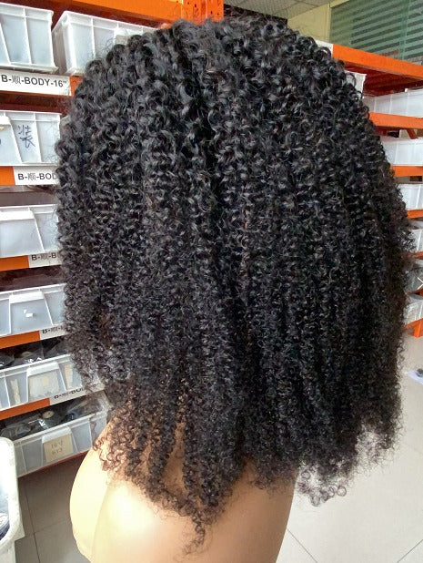 A beautiful 13x1x4 Afro Kinky Curly T Part Lace Wig made from 100% human hair, showcasing its natural curls and transparent lace.