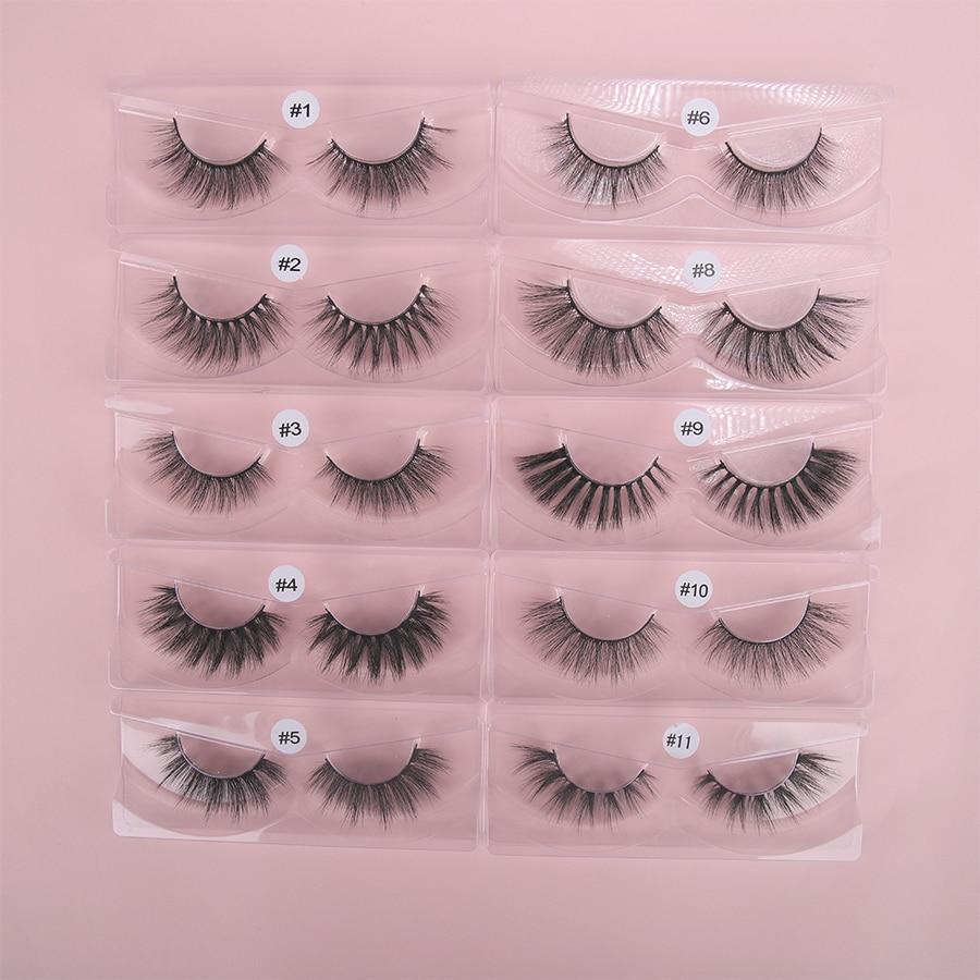 A collection of 50/100 pairs of hand-made 3D Mink Eyelashes in a display, showcasing their natural long style and soft synthetic hair material.