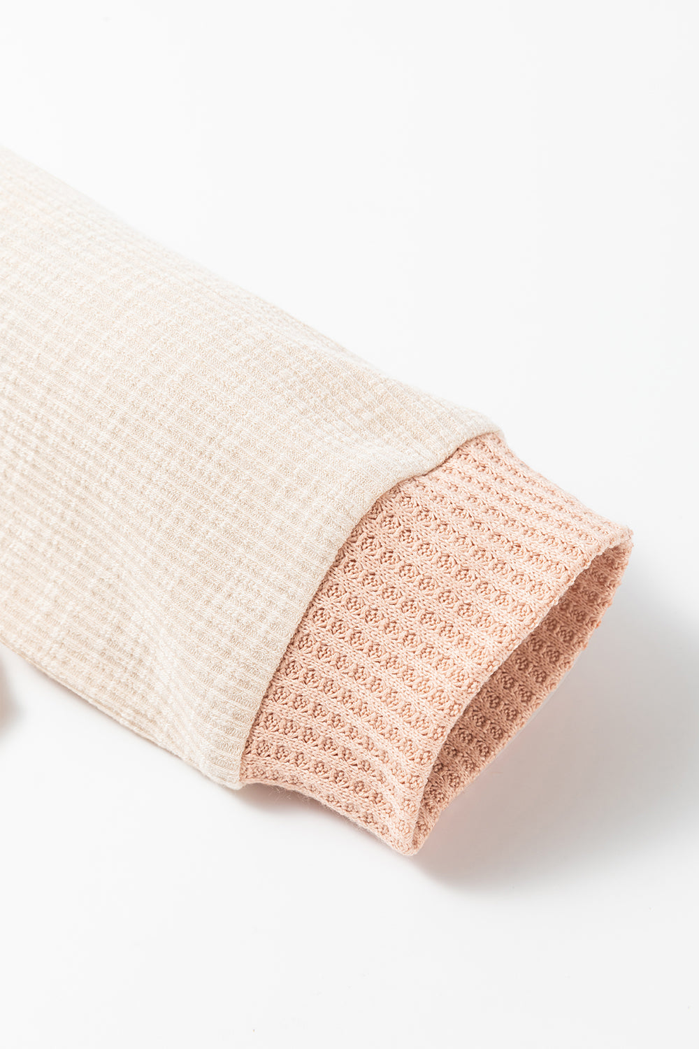 Apricot oversized knit top featuring a waffle contrast design, showcasing a stylish turn-down collar and textured fabric.