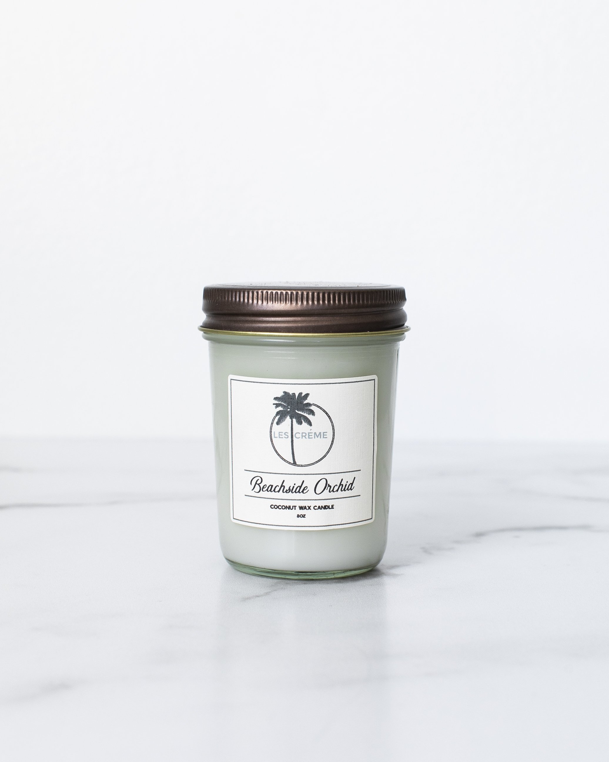 Beachside Orchid Scent Coconut Wax Candle in a stylish jar, showcasing its tropical design and natural ingredients.