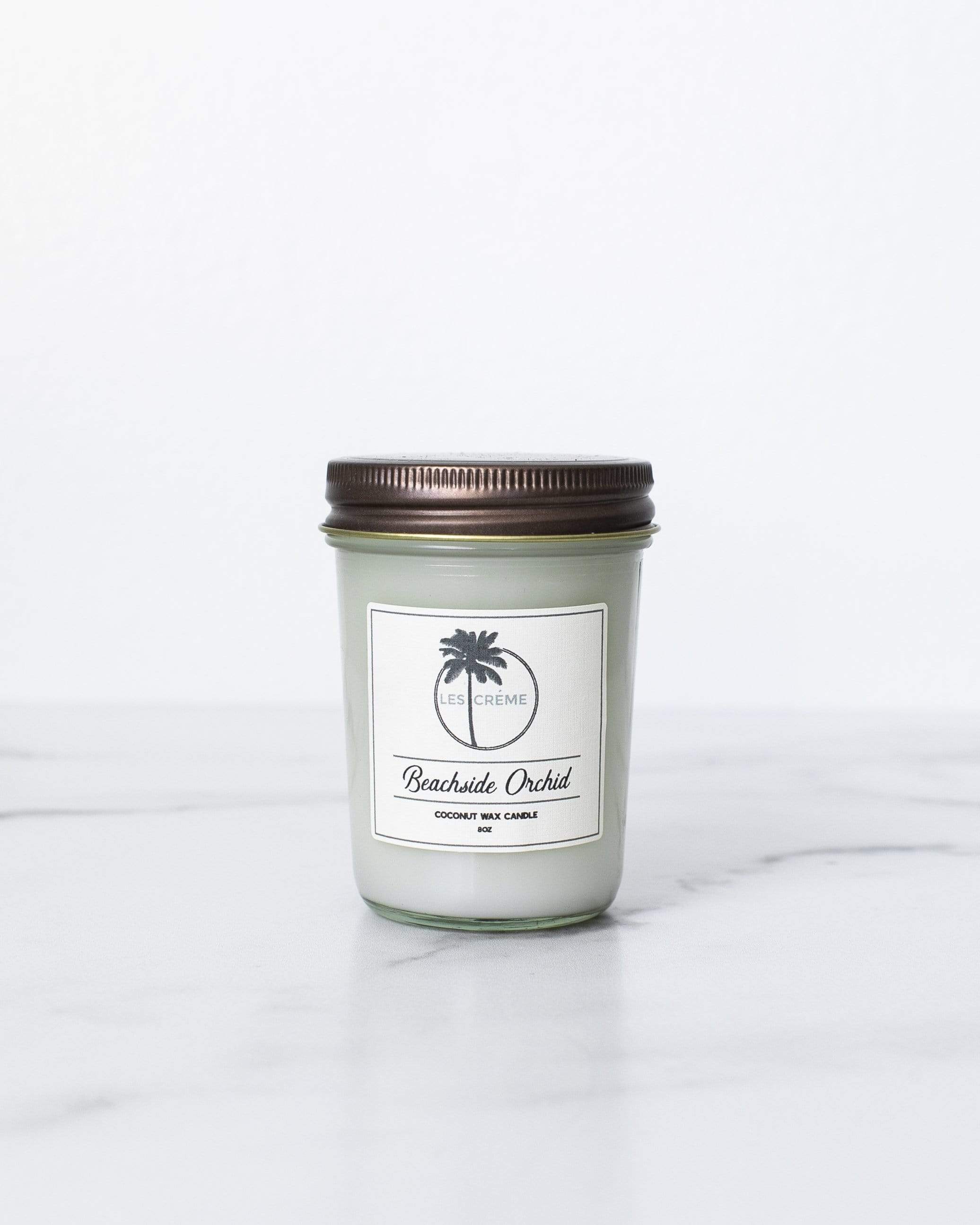 Beachside Orchid Scent Coconut Wax Candle in a stylish jar, showcasing its tropical design and natural ingredients.