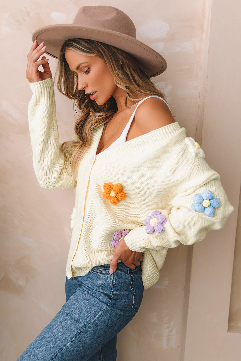 Beige cardigan sweater with colorful flower embellishments and button-up front, perfect for winter fashion.