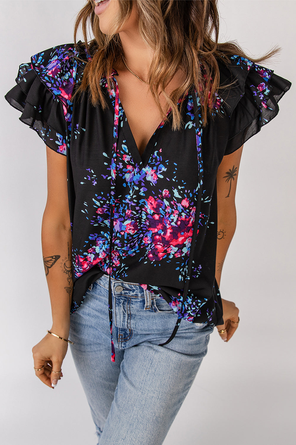 Black blouse with butterfly sleeves and split V-neck, featuring a colorful tie-dye print, perfect for stylish women.