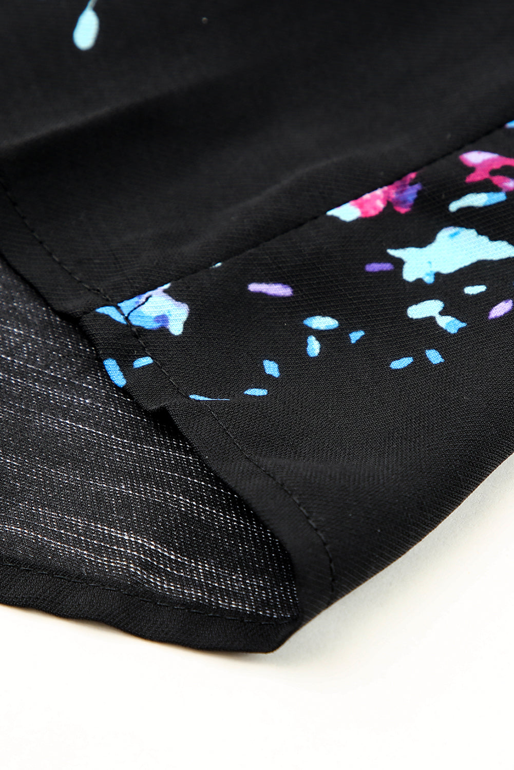 Black blouse with butterfly sleeves and split V-neck, featuring a colorful tie-dye print, perfect for stylish women.