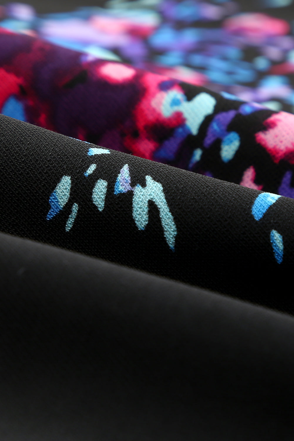 Black blouse with butterfly sleeves and split V-neck, featuring a colorful tie-dye print, perfect for stylish women.