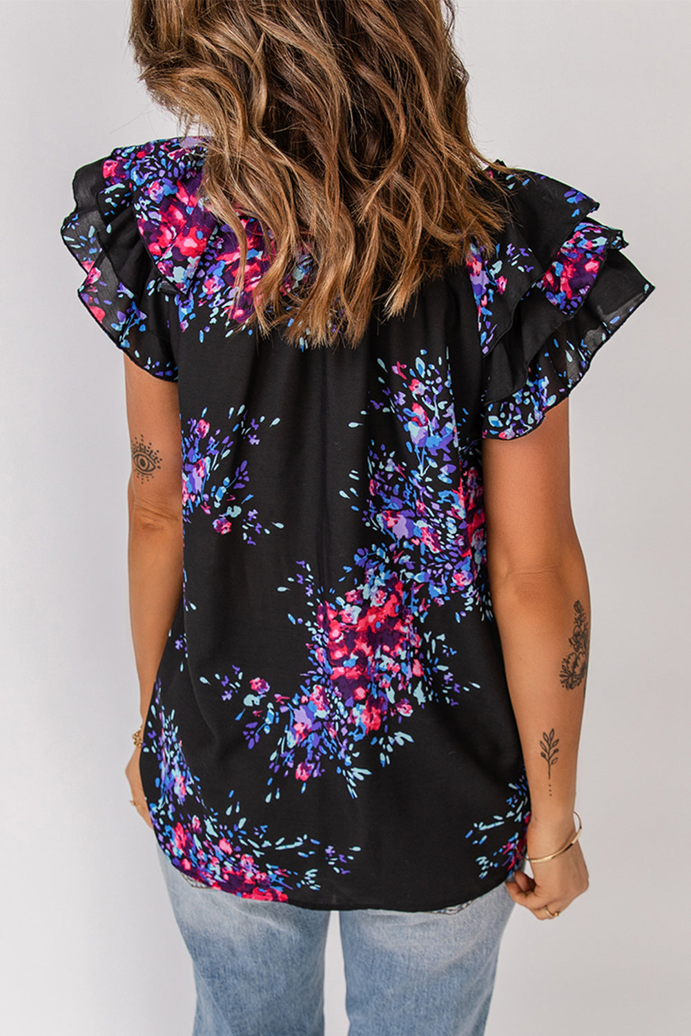 Black blouse with butterfly sleeves and split V-neck, featuring a colorful tie-dye print, perfect for stylish women.