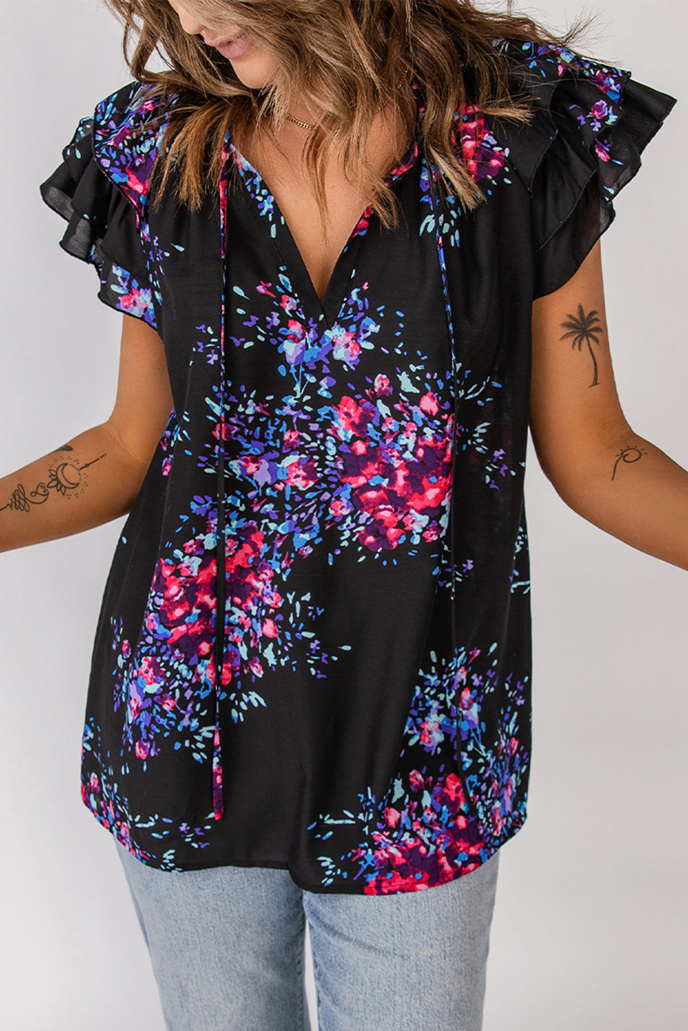 Black blouse with butterfly sleeves and split V-neck, featuring a colorful tie-dye print, perfect for stylish women.