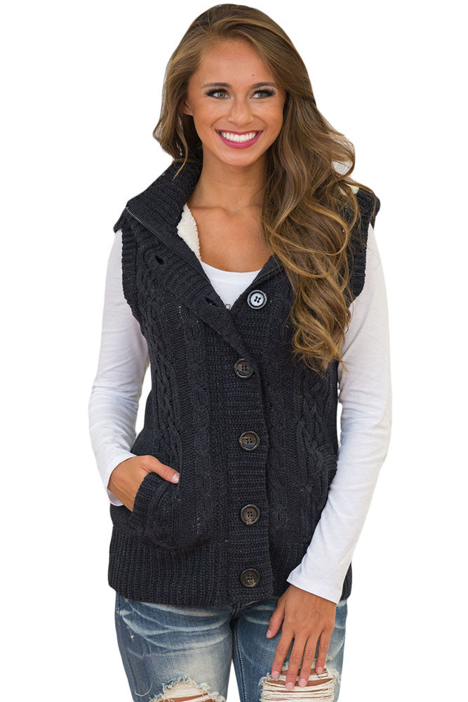 A stylish black cable knit hooded sweater vest featuring a zip front, decorative buttons, and fleece-lined hood, perfect for layering.