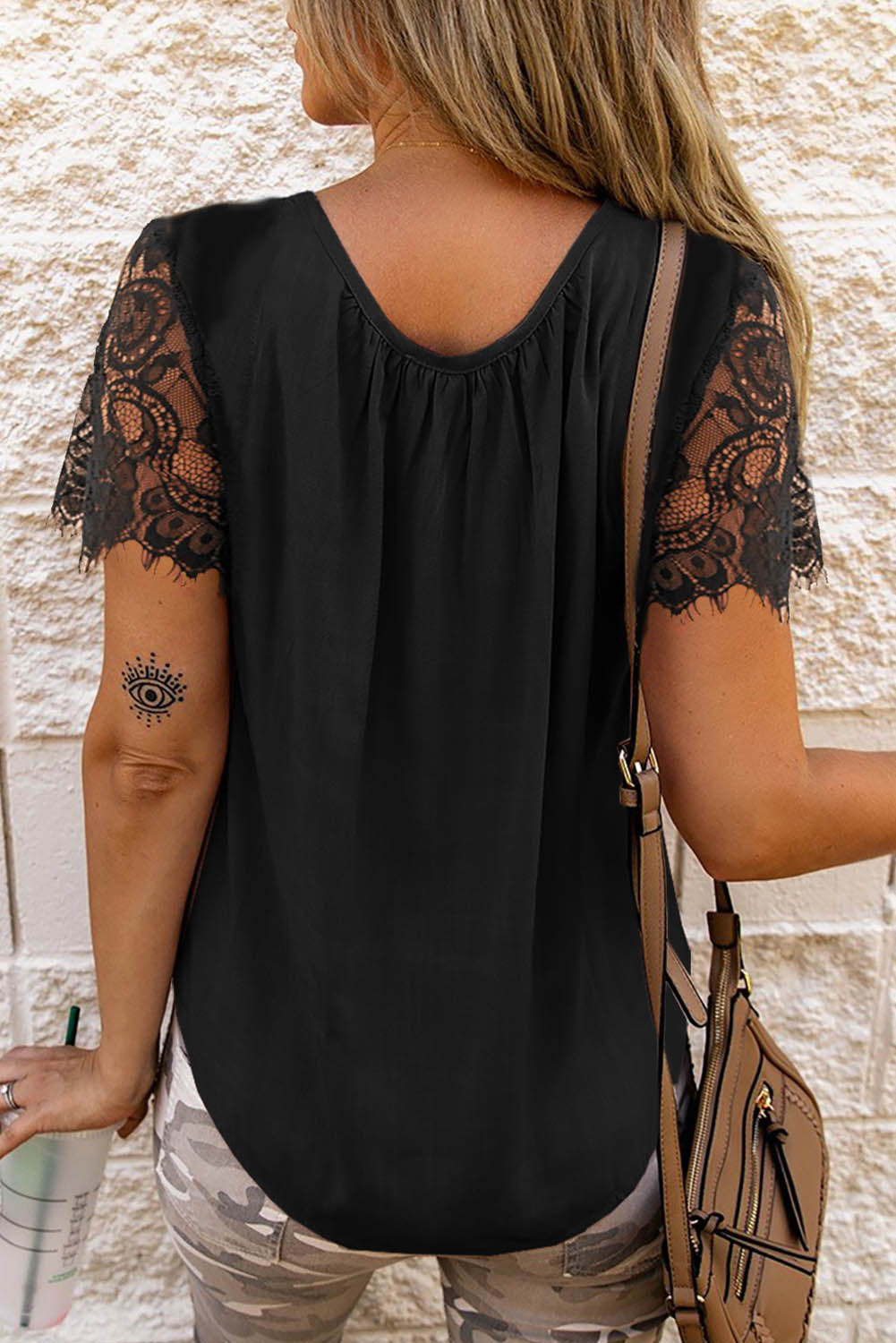 Black short sleeve top featuring cut-out design and lace patchwork, perfect for stylish casual wear.