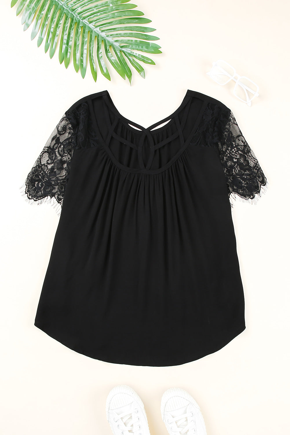Black short sleeve top featuring cut-out design and lace patchwork, perfect for stylish casual wear.