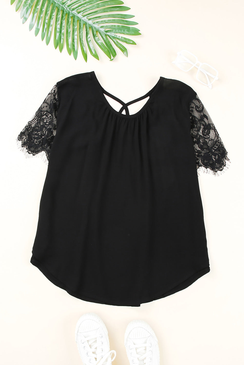 Black short sleeve top featuring cut-out design and lace patchwork, perfect for stylish casual wear.