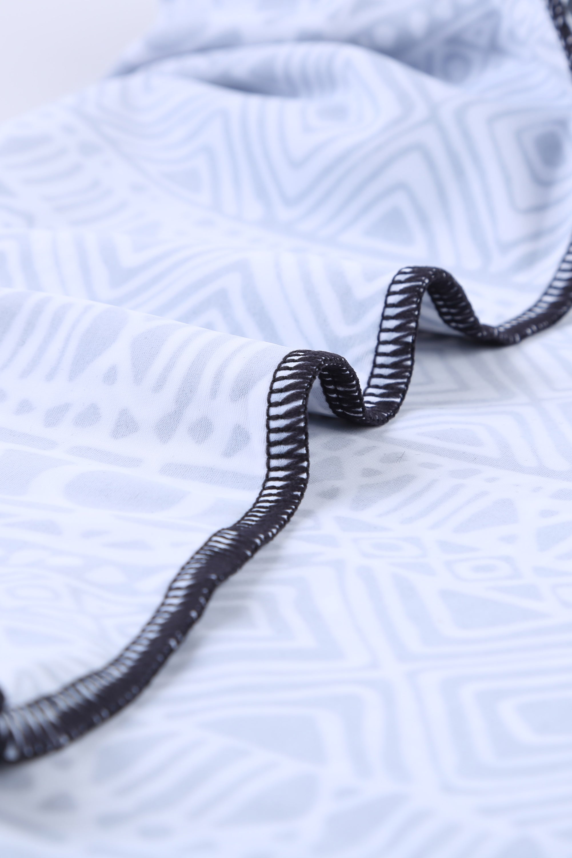 Black ethnic print high neck strappy tankini top designed for stylish swimwear with body shaping control.