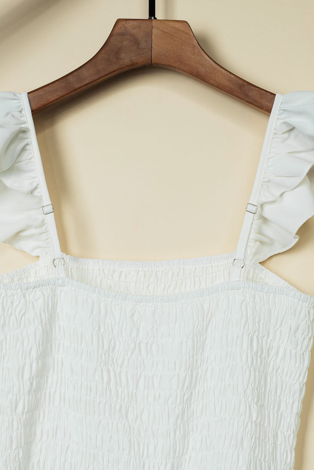 A stylish black jumpsuit featuring flutter sleeves, a smocked bodice, and wide leg bottoms, perfect for any occasion.