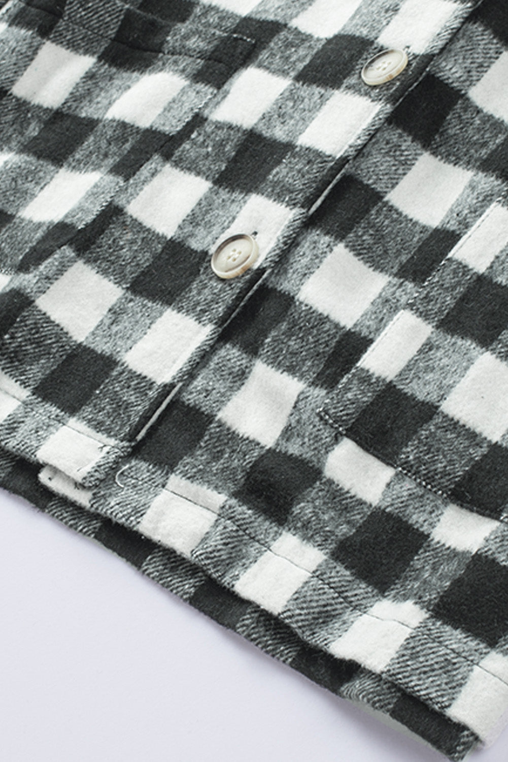 Black fringed plaid print shacket featuring a classic black and white pattern, collared neckline, and stylish fringe details on sleeves.