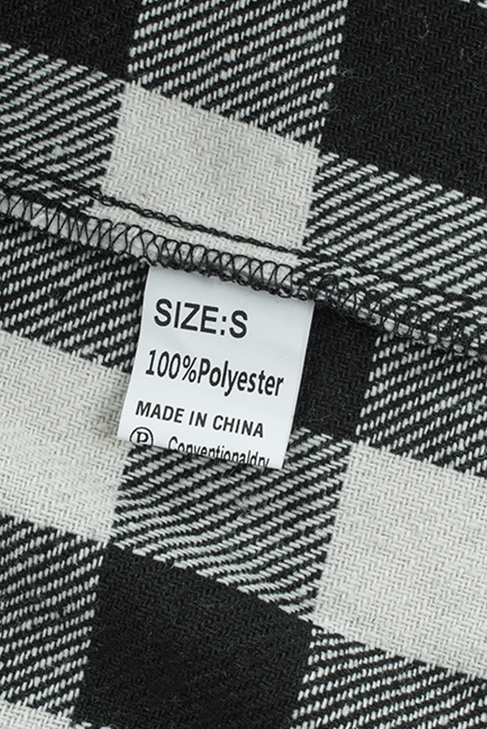 Black fringed plaid print shacket featuring a classic black and white pattern, collared neckline, and stylish fringe details on sleeves.