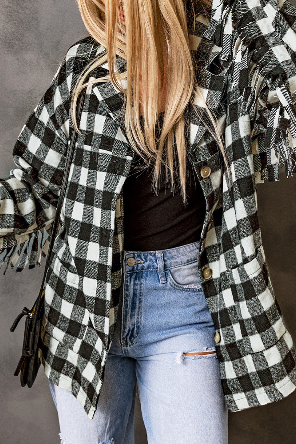 Black fringed plaid print shacket featuring a classic black and white pattern, collared neckline, and stylish fringe details on sleeves.